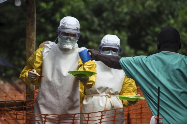 Medical staff working with Medecins sans Frontieres prepare to bring food to patients kept in an isolation area at the MSF Ebola treatment centre in Kailahun