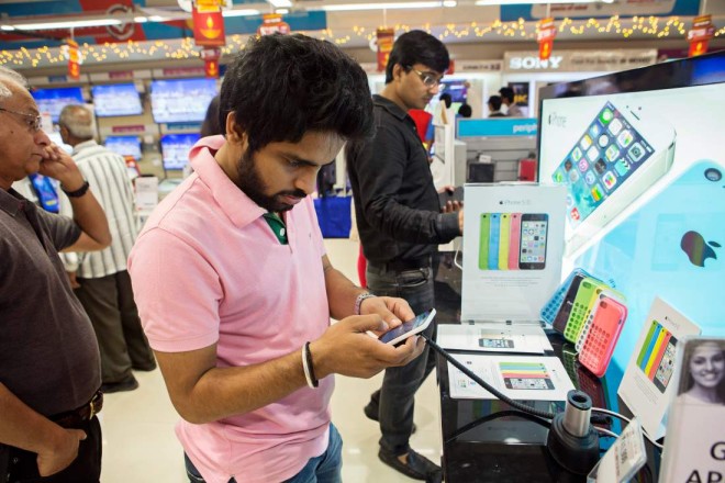 A customer tries out an Apple Inc. iPhone 5C at a Reliance Digital store, a subsidiary of Reliance Industries Ltd., in New Delhi, India, on Saturday, Nov. 2, 2013. Reliance Communications Ltd. is the first Indian carrier to sell Apples iPhone with a service contract. Reliance will offer customers the iPhone 5S and 5C a two-year contract with bundled data services. Photographer: Prashanth Vishwanathan/Bloomberg via Getty Images