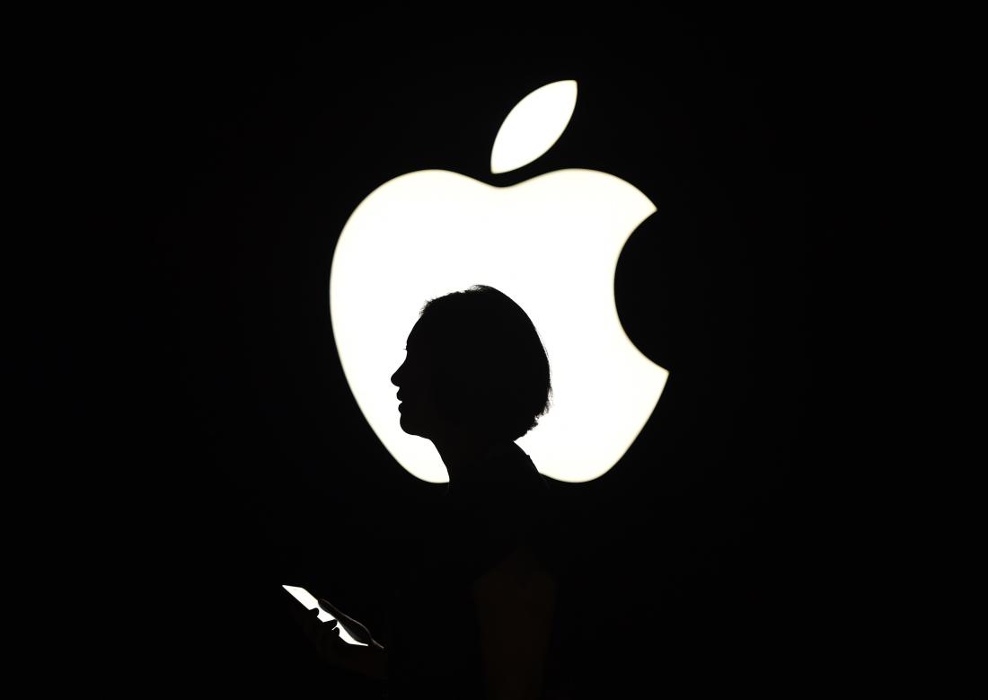 A reporter walks by an Apple logo during a media event in San Francisco, California on September 9, 2015. Apple unveiled its iPad Pro, saying the large-screen tablet has the power and capabilities to replace a laptop computer.    AFP PHOTO/JOSH EDELSON        (Photo credit should read Josh Edelson/AFP/Getty Images)