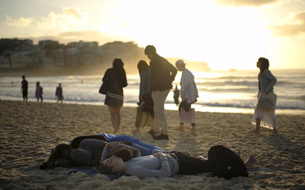 Visitors to Australia's Bondi Beach sleep after a night of celebrations as the first sunrise of the new year arrives in Sydney