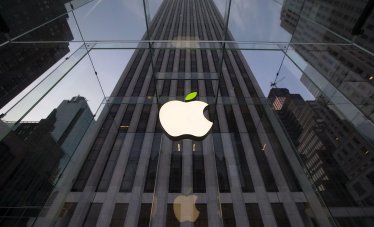 The leaf on the Apple symbol is tinted green at the Apple flagship store on 5th Avenue in New York, in this file picture taken April 22, 2014. Through bursting bubbles and crashing markets, revenue and profit at America's top companies have expanded smartly over the past 18 years -- nearly tripling in the case of operating income. A Reuters analysis of revenue, operating profit and head count growth at the 100 largest non-bank companies between 1995 and 2013 documents a steady divergence between their ability to generate earnings and the need to hire employees. To match Insight USA-ECONOMY/EMPLOYMENT    REUTERS/Brendan McDermid/Files  (UNITED STATES - Tags: ENVIRONMENT SCIENCE TECHNOLOGY BUSINESS)
