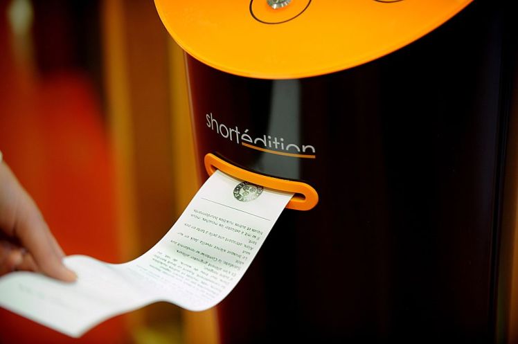 A woman chooses a short story at a short-story distribution terminal in the Mistral district of Grenoble, on October 12, 2015. The city of Grenoble is testing the invention of a local start-up and recently installed the terminal, which delivers free reading material to people waiting in public spaces.  AFP PHOTO / JEAN-PERRE CLATOT        (Photo credit should read JEAN-PIERRE CLATOT/AFP/Getty Images)