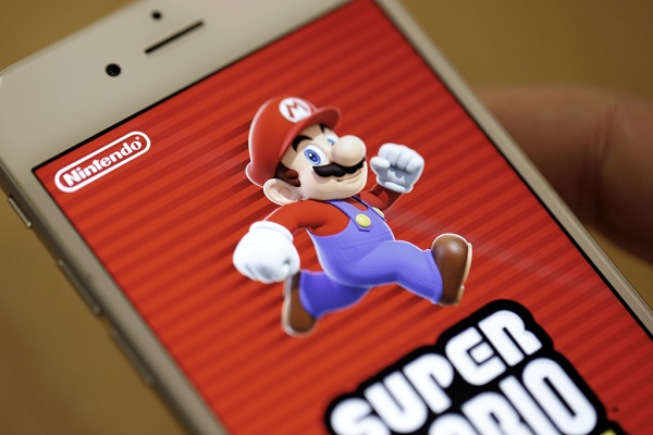 The title screen of Nintendo Co.'s Super Mario Run mobile game is displayed on an iPhone screen in this arranged photograph in Tokyo, Japan, on Monday, Dec. 19, 2016. Nintendo plummeted in Tokyo after the debut of Super Mario Run was met by lukewarm reviews. Photographer: Takaaki Iwabu/Bloomberg via Getty Images