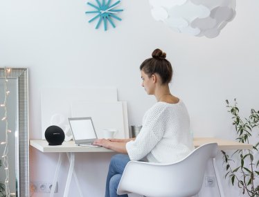 Girl working on laptop in white room