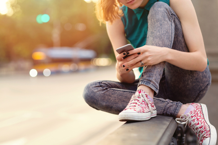 Teenage girl breaking up with her boyfriend while sitting on a bridge near big boulevard. Casual clothing with shirt and jeans.