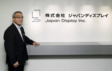 Japan Display Inc Chief Executive Mitsuru Homma poses in front of the company's logo at its headquarters in Tokyo September 3, 2015.  REUTERS/Thomas Peter