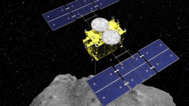 In this computer graphics image released by the Japan Aerospace Exploration Agency (JAXA), the Hayabusa2 spacecraft is seen above on the asteroid Ryugu. Japan's space agency JAXA said Friday, April 5, 2019, its Hayabusa2 spacecraft released an explosive onto an asteroid to make a crater on its surface and collect underground samples to find possible clues to the origin of the solar system. The mission is the riskiest for Hayabusa2, as it has to immediately get away so it won't get hit by flying shards from the blast. (ISAS/JAXA via AP)