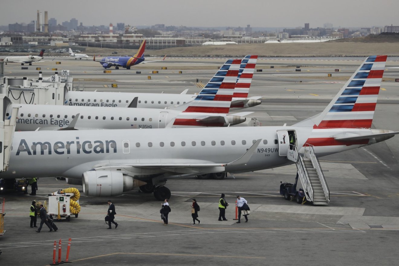 Passengers leave an American Airlines plane at LaGuardia Airport Wednesday, March 13, 2019, in New York. (AP Photo/Frank Franklin II)