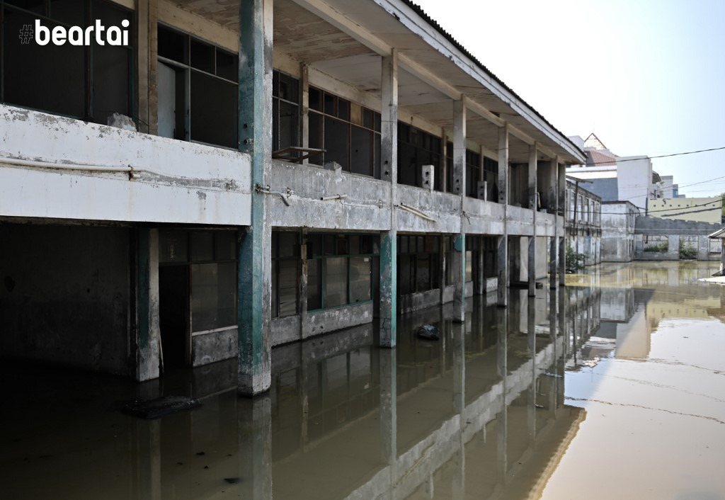 In this picture taken on July 26, 2019 shops are submerged as seen in northern Jakarta. - Indonesia's capital is being swallowed into the ground at such an alarming rate that experts warn much of it could be submerged by 2050. (Photo by BAY ISMOYO / AFP) / TO GO WITH STORY: Indonesia-environment-social, by Dessy SAGITA