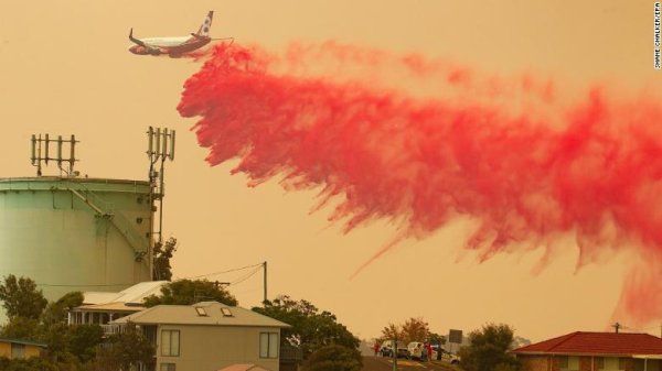 เครื่องบินกำลังทิ้งสารที่ชะลอเปลวเพลิงลงพื้นที่ไฟป่า