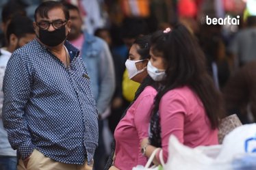ผู้คนในอินเดียสวมหน้ากากอนามัยป้องกันการแพร่กระจายของ COVID-19