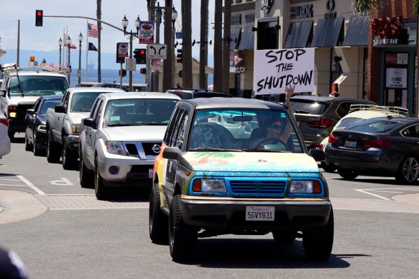 ประชาชนขับรถออกมาประท้วงมาตการล็อกดาวน์ประเทศ ที่ชายหาด Huntington ในรัฐแคลิฟอร์เนียของสหรัฐฯ