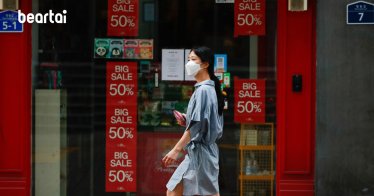 แฟ้มภาพซินหัว : หญิงสวมหน้ากากอนามัยเดินผ่านร้านค้าติดป้ายลดราคา ในย่านชอปปิงเมียงดง กรุงโซล เมืองหลวงของเกาหลีใต้ วันที่ 5 ก.ย. 2020