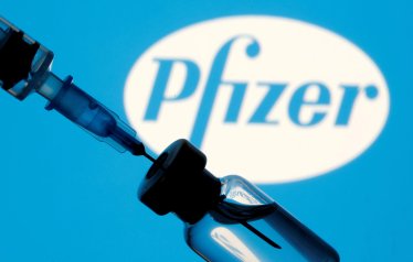 FILE PHOTO: A vial and sryinge are seen in front of a displayed Pfizer logo in this illustration taken January 11, 2021. REUTERS/Dado Ruvic/Illustration