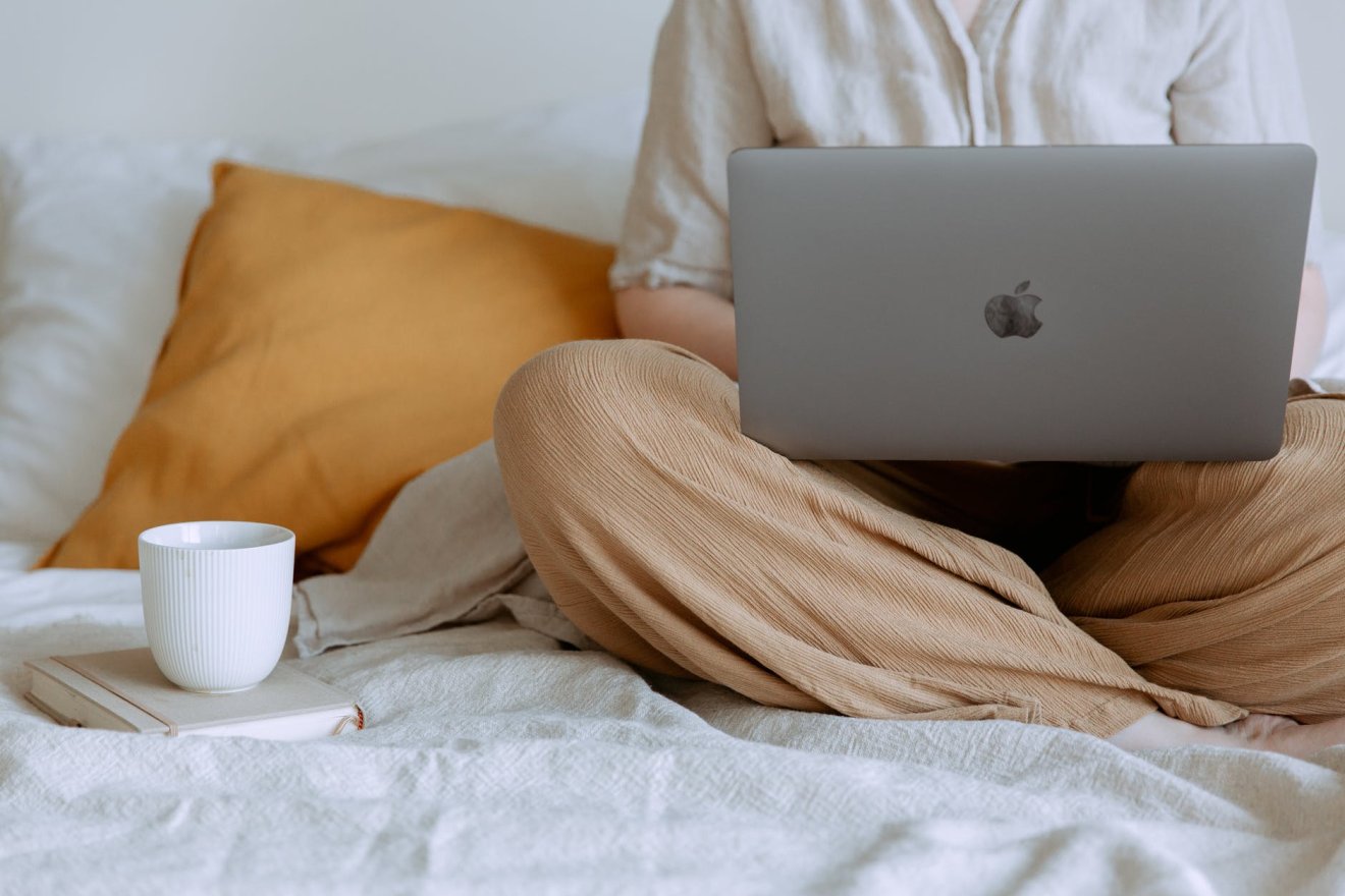 anonymous woman using laptop in bedroom