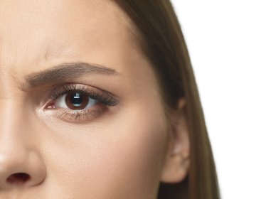 Close-up portrait of young woman's eyes and face with wrinkles. Female model with well-kept skin. Concept of health and beauty, cosmetology, cosmetics, self-care, body and skin care. Anti-aging.