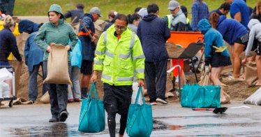 People fill up sandbags at a public collection point in preparation for the arrival of Cyclone Gabrielle in Auckland, New Zealand, February 12, 2023. AAP Image/David Rowland via REUTERS