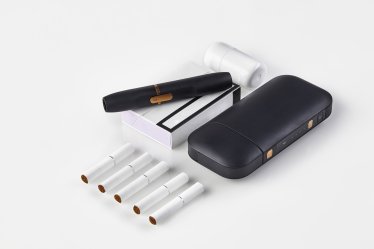 New generation black electronic cigarette and battery, cleaner, one pack and five heatsticks isolated on white. Heating tobacco system. Tools used to help stop smoking. Close up, copy space