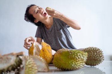 portrait of happy woman enjoy eating durian fruit
