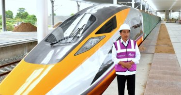 Indonesian President Joko Widodo stands beside a high-speed train