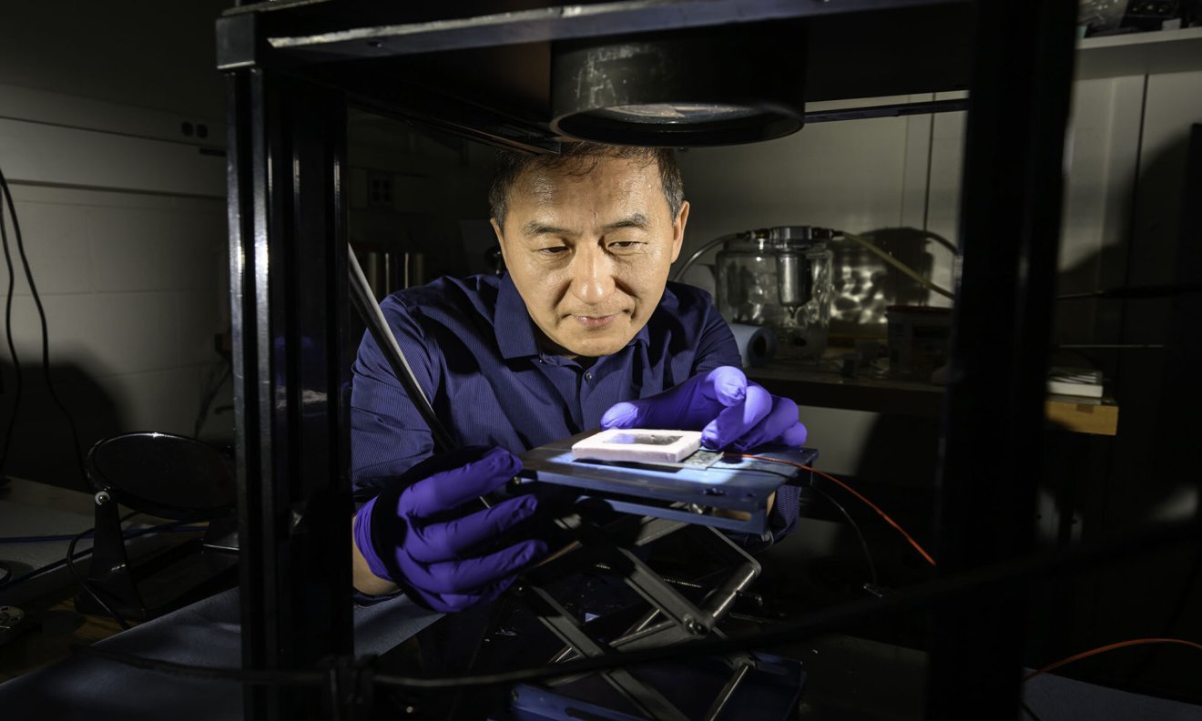University of Rochester Institute of Optics professor Chunlei Guo uses a source of simulated sunlight to test the absorption of a solar thermoelectric generator created in his lab in Wilmot Building May 30, 2025. Guo has developed a technique that uses femtosecond lasers to etch nanostructures onto metal surfaces that enhance solar absorption but minimize infrared emissions to create highly efficient solar thermoelectric generators. // photo by J. Adam Fenster / University of Rochester